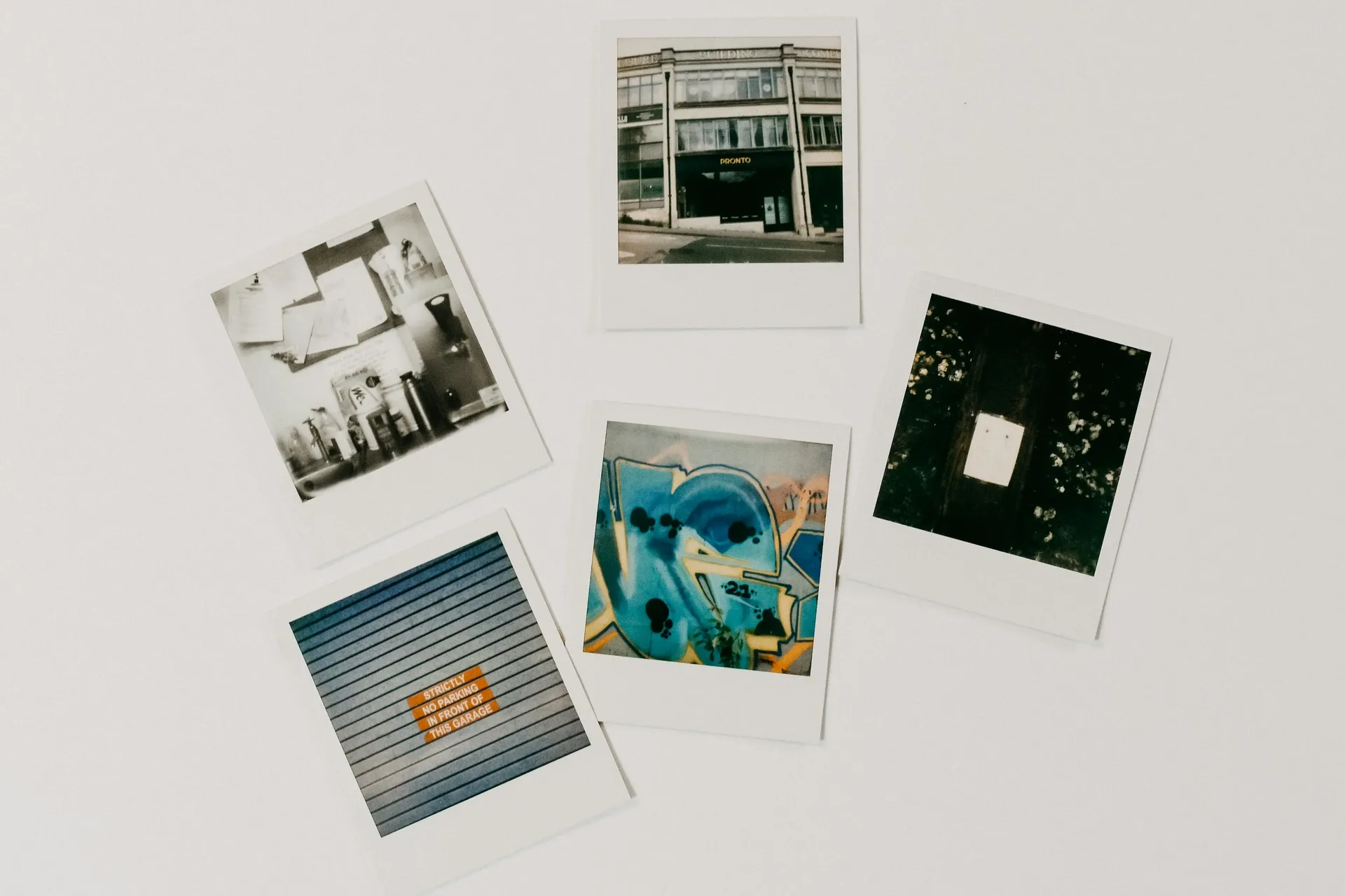 Five instant photos scattered on a pale table